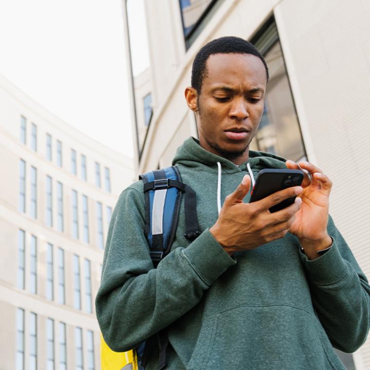 Male college student looking at his phone