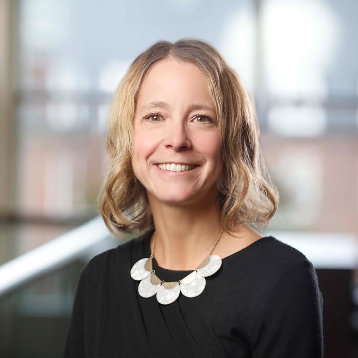 Theresa Danylak standing in the Warner School's LeChase Hall, smiling at the camera.