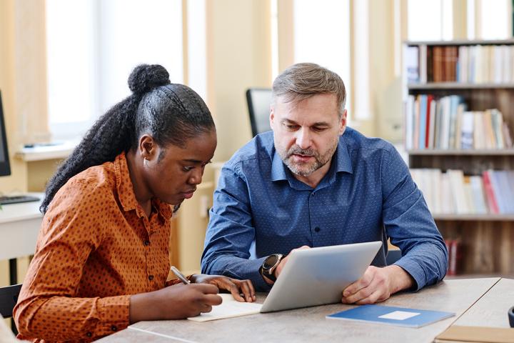 Professor helping student in classroom